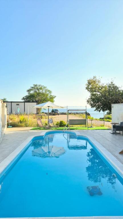 a large blue swimming pool with a view of the ocean at Studio Apartmani Šehić in Krvavica