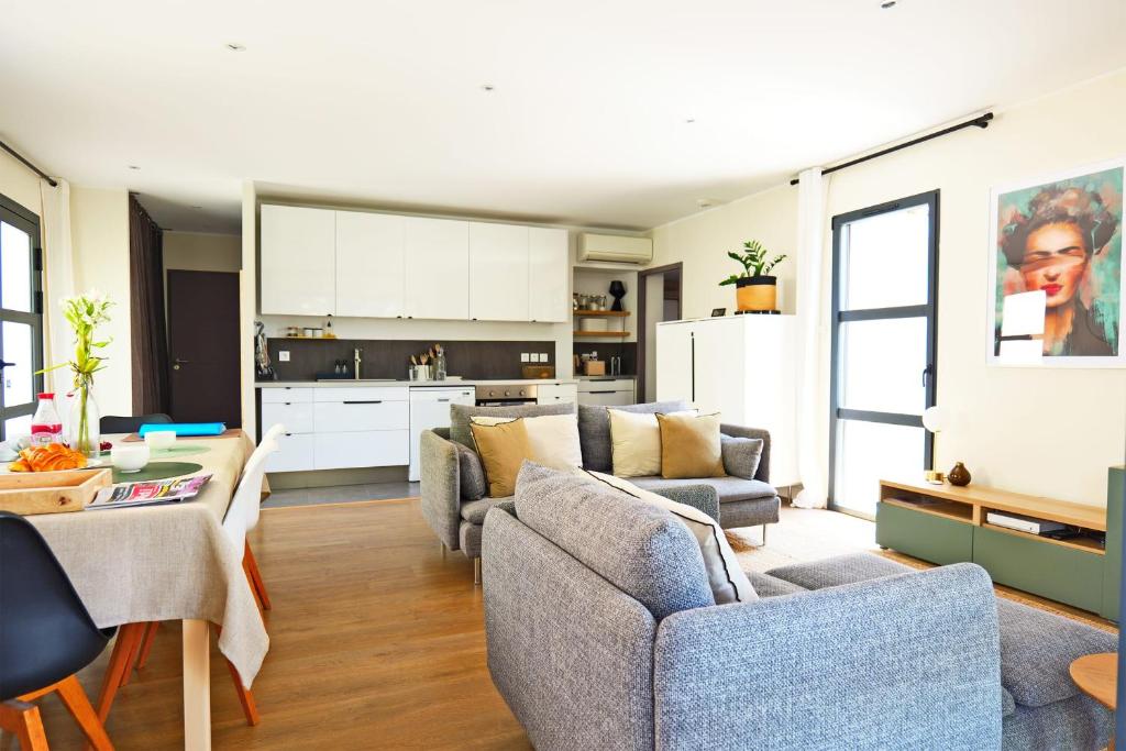 a living room with a couch and a table at Maison des Paradisiers - Welkeys in Le Crès