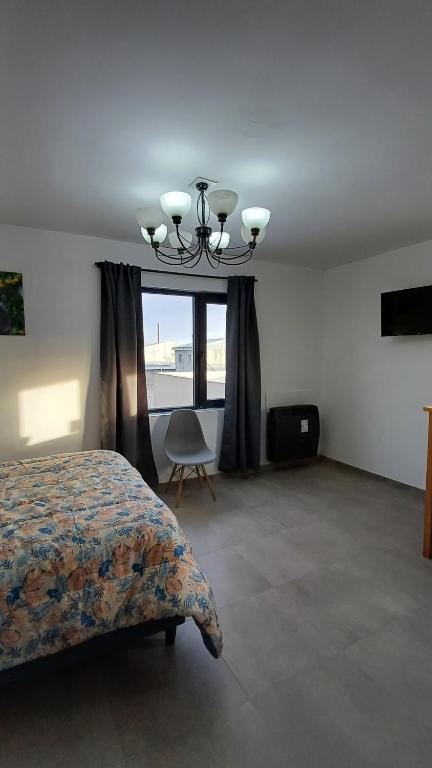 a bedroom with a bed and a window with a chair at Brisa Marina in Río Grande