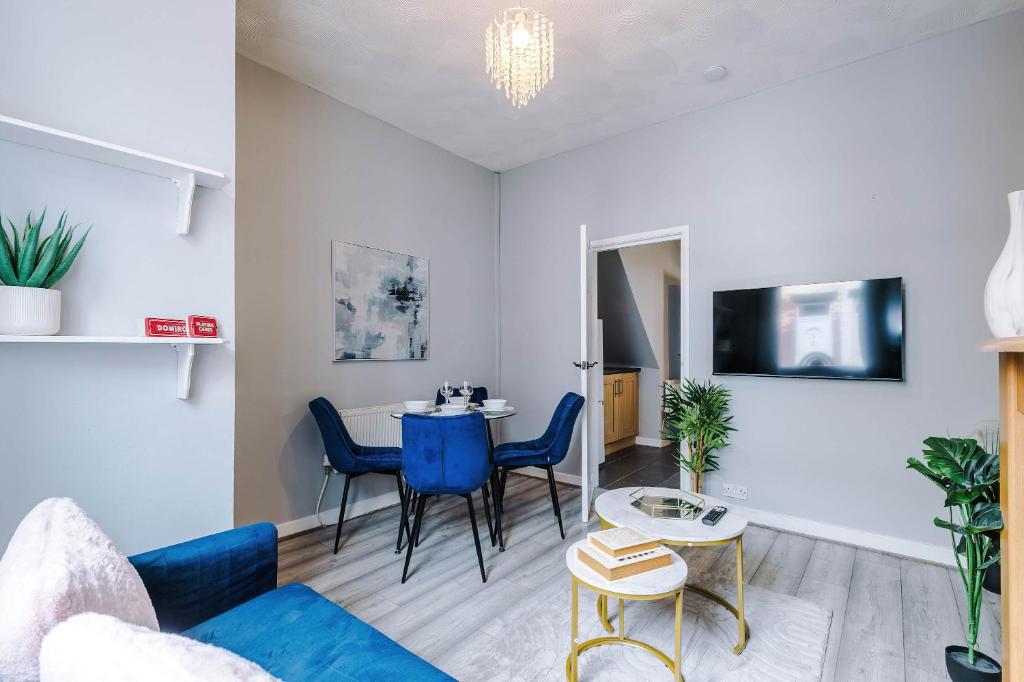 a living room with a blue couch and a table at St Helens Central, 2 Bed , Long Stays OFFERS , Contractors , Relocations , Families , Sleeps 4 in Saint Helens