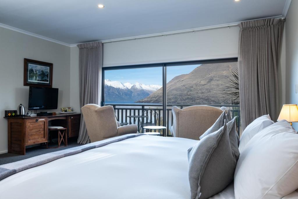 ein Hotelzimmer mit einem Bett und Bergblick in der Unterkunft Hidden Lodge Queenstown in Queenstown