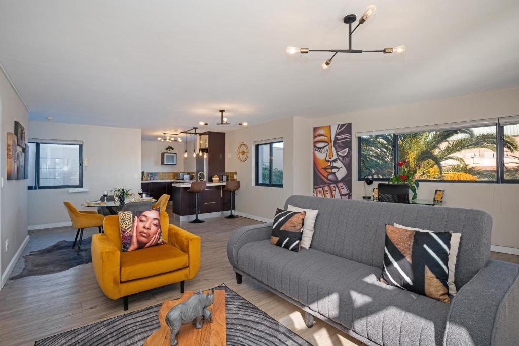 a living room with a couch and a yellow chair at Knightsbridge Terrace in Cape Town