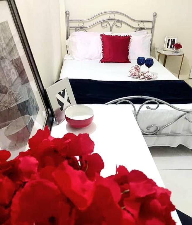 a bedroom with a bed with red flowers on it at The Hibiscus Retreat in Arima