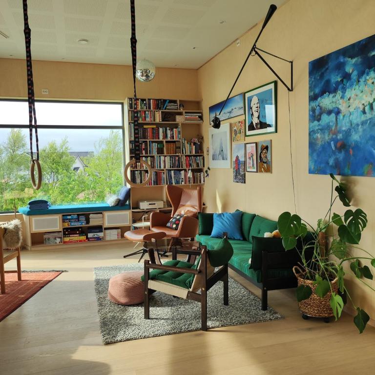 a living room with a green couch and chairs at Villa by the sea in Vesterålen 