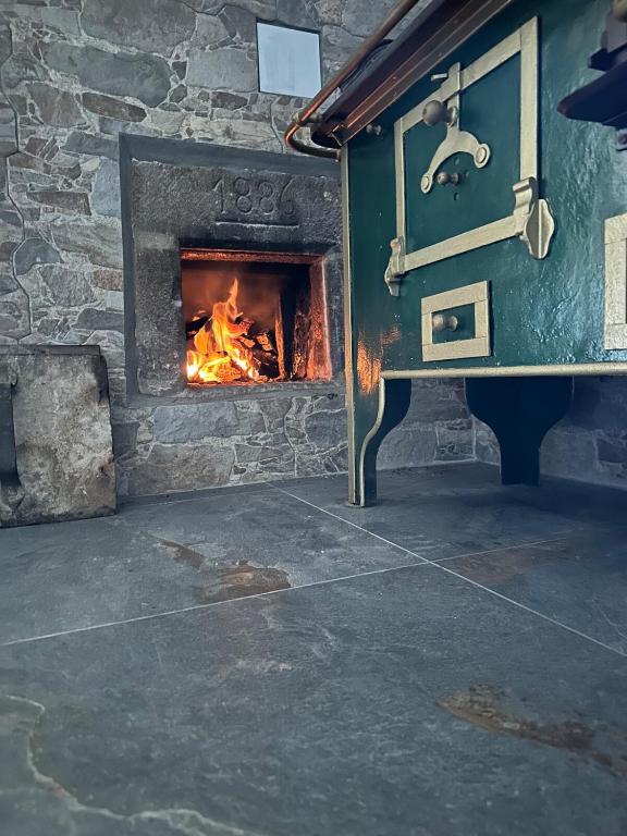 a stone oven with a fire in it at Casa Soraya 2 in Falcade