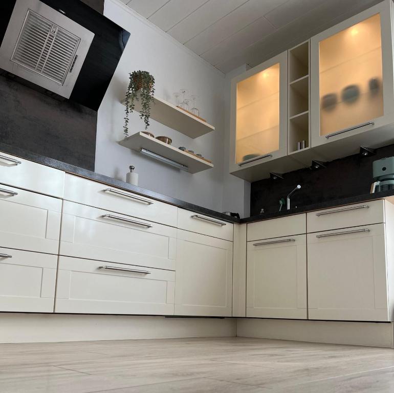 a kitchen with white cabinets and a sink at ZwoLu Apartments in Bornheim