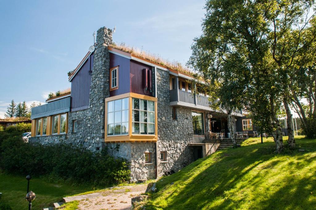 einen Blick auf ein Steinhaus auf einem Hügel in der Unterkunft Dolmsundet Hotell Hitra in Melandsjøen