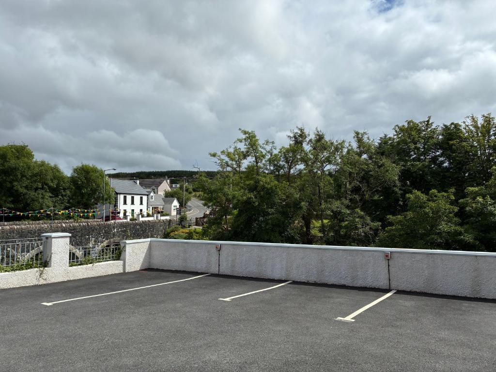 a parking lot with a white house in the background at Carrick Gate in Carrick