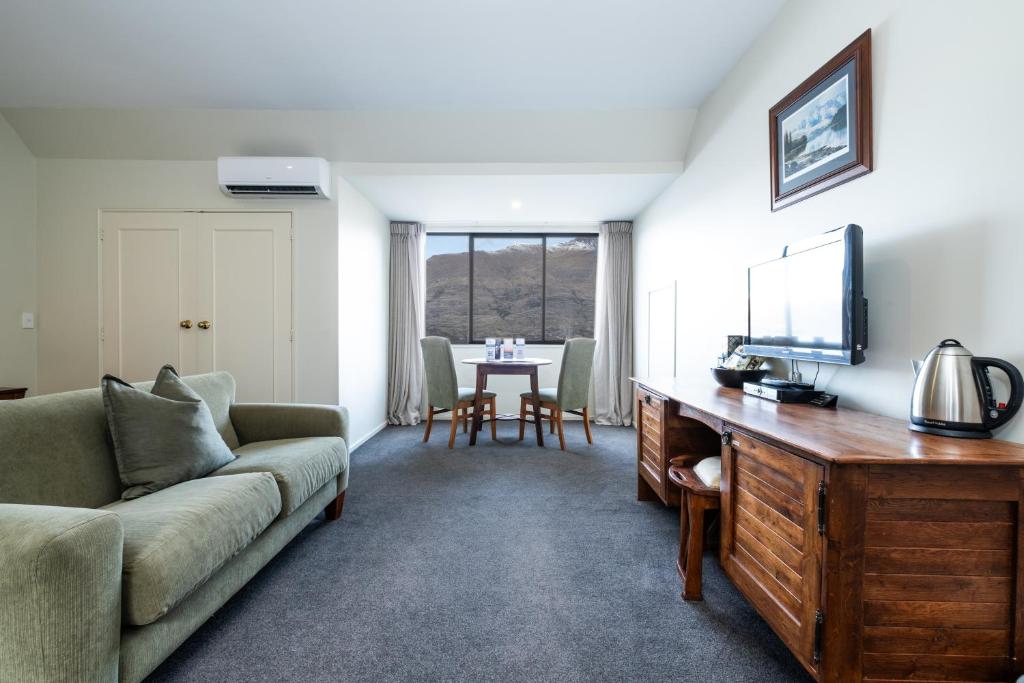 ein Wohnzimmer mit einer Couch und einem Tisch in der Unterkunft Hidden Lodge Queenstown in Queenstown