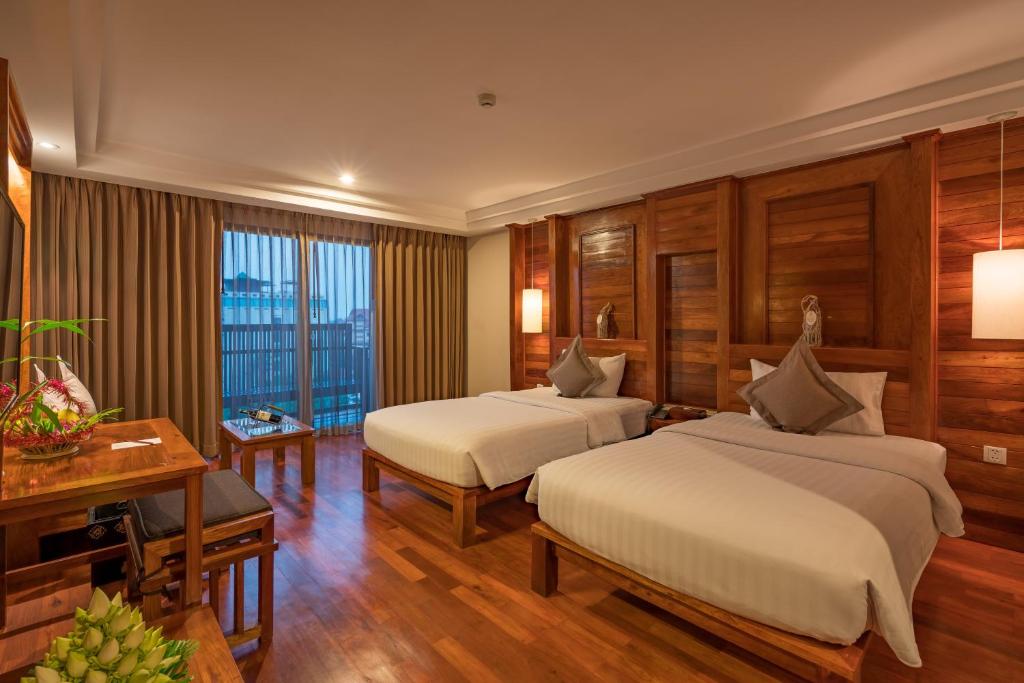 Postel nebo postele na pokoji v ubytování Angkor Miracle Resort & Spa