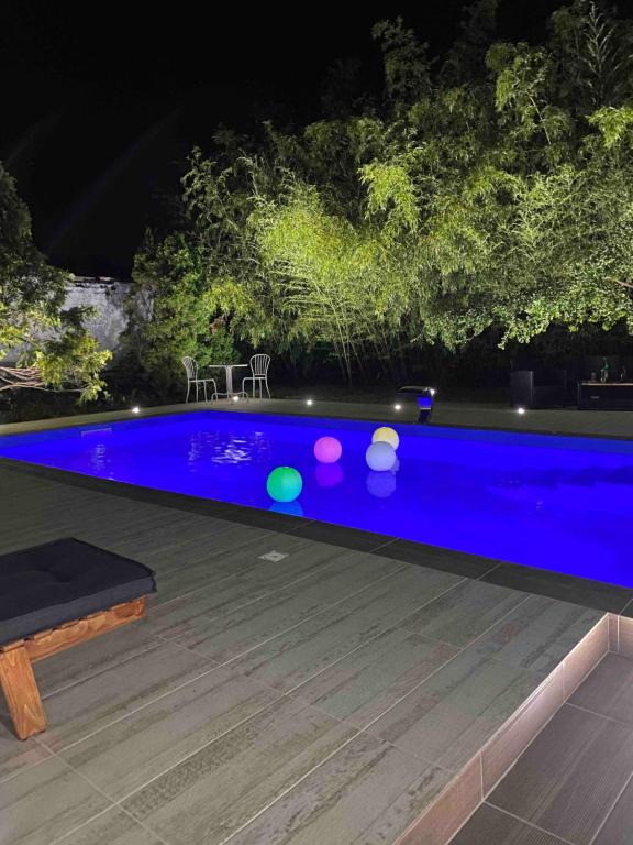 a blue swimming pool at night with a bench at Ilkićev kućerak Studio in Vrdnik