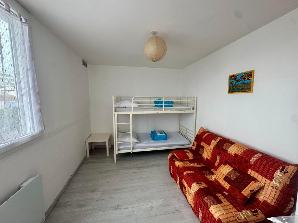 a living room with a couch and a shelf at Mauves et Marées plage à 300m in Saint-Hilaire-de-Riez