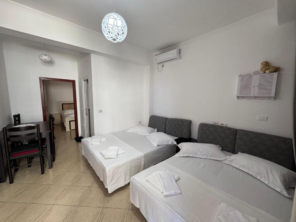 a hotel room with two beds and a desk at Hotel Barjami in Sarandë