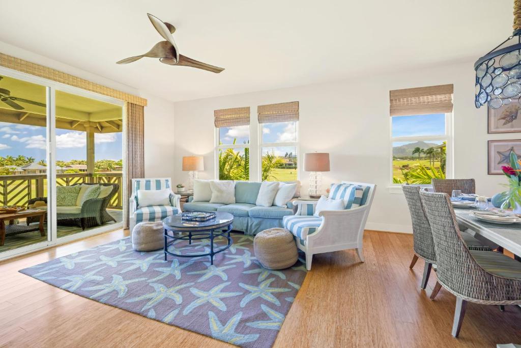a living room with a blue couch and a table at Pili Mai 8K in Koloa