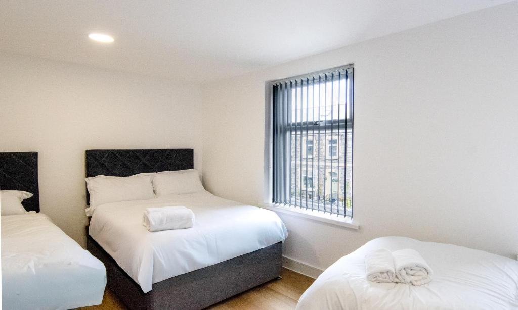 a small bedroom with two beds and a window at Best 2BR Flat in Cardiff Near Town Centre in Cardiff