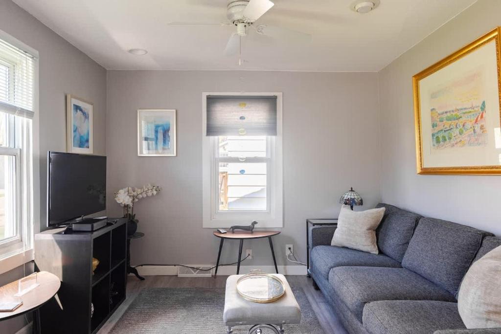 ein Wohnzimmer mit einem blauen Sofa und einem Fernseher in der Unterkunft Corporate insurance or family vacation in Wolverine lake in Walled Lake