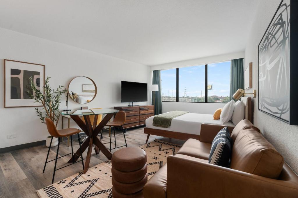 um quarto com uma cama e uma sala de estar com um sofá em Lodgeur Upper Kirby, Houston - Close to Greenway Plaza, Galleria, Montrose em Houston