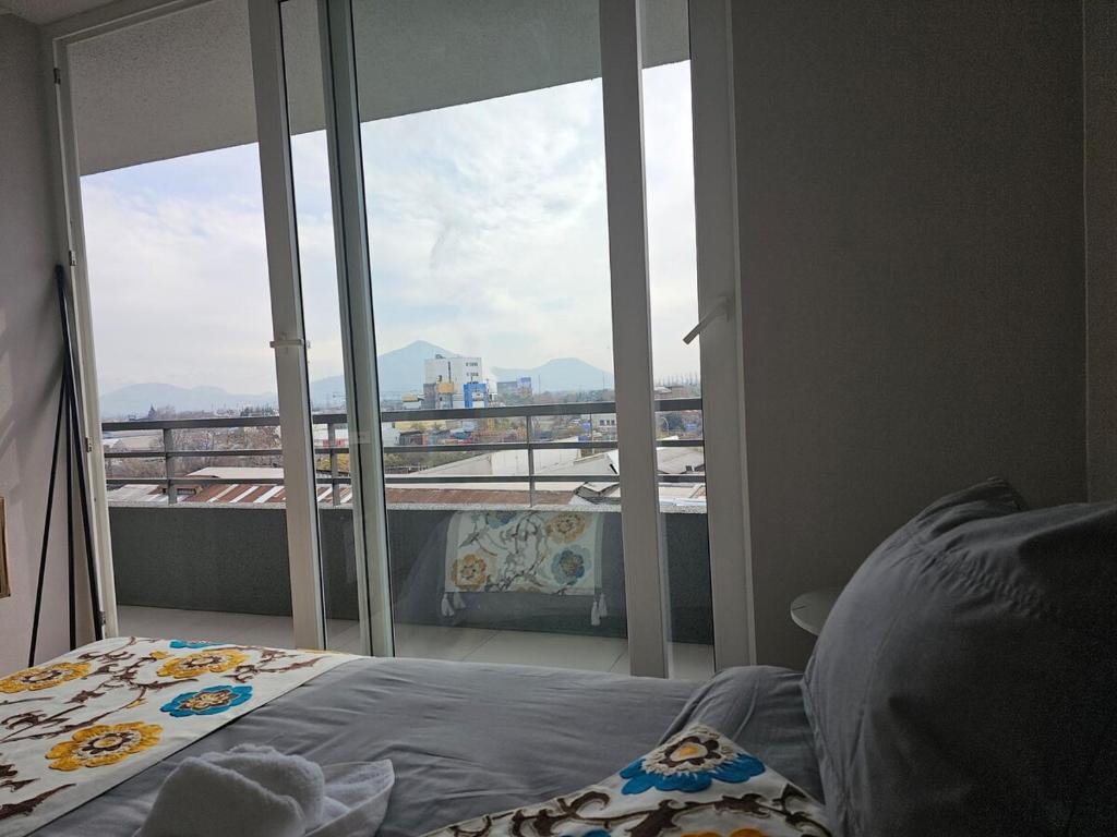 a bedroom with a bed and a large window at Central apartment in historic Barrio Yungay, en pleno centro de Santiago in Santiago