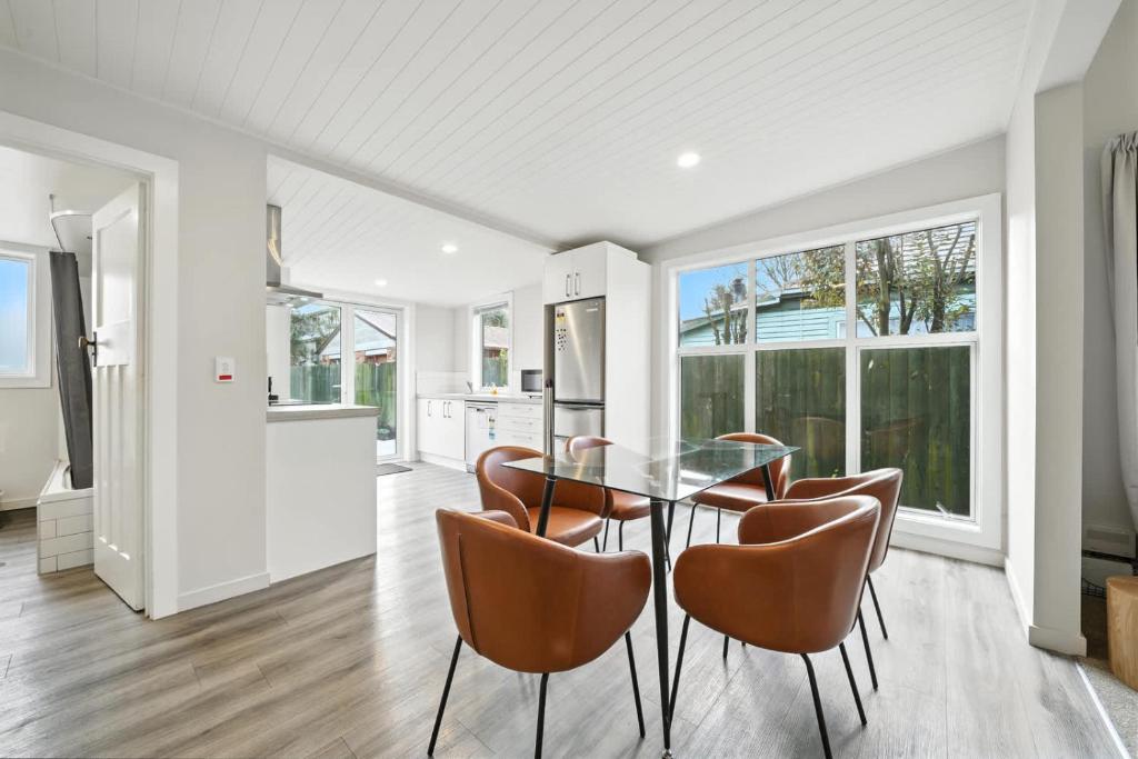 une cuisine et une salle à manger avec une table et des chaises en verre dans l'établissement Albemarle Villa, à Christchurch