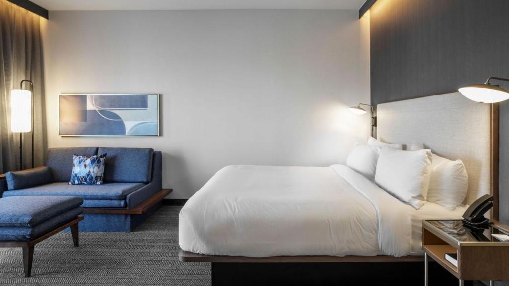 una camera d'albergo con un letto e un divano di Courtyard by Marriott Madison Huntsville a Madison