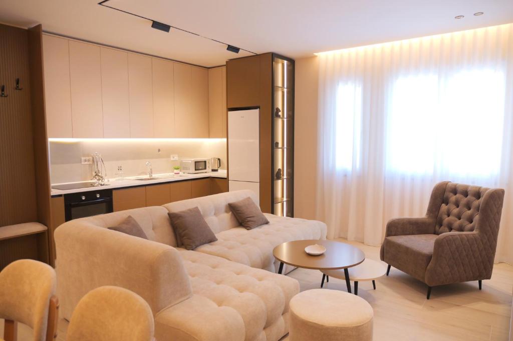 a living room with a couch and a table and chairs at HORIZONT Premium Apart-Hotel in Shkodër