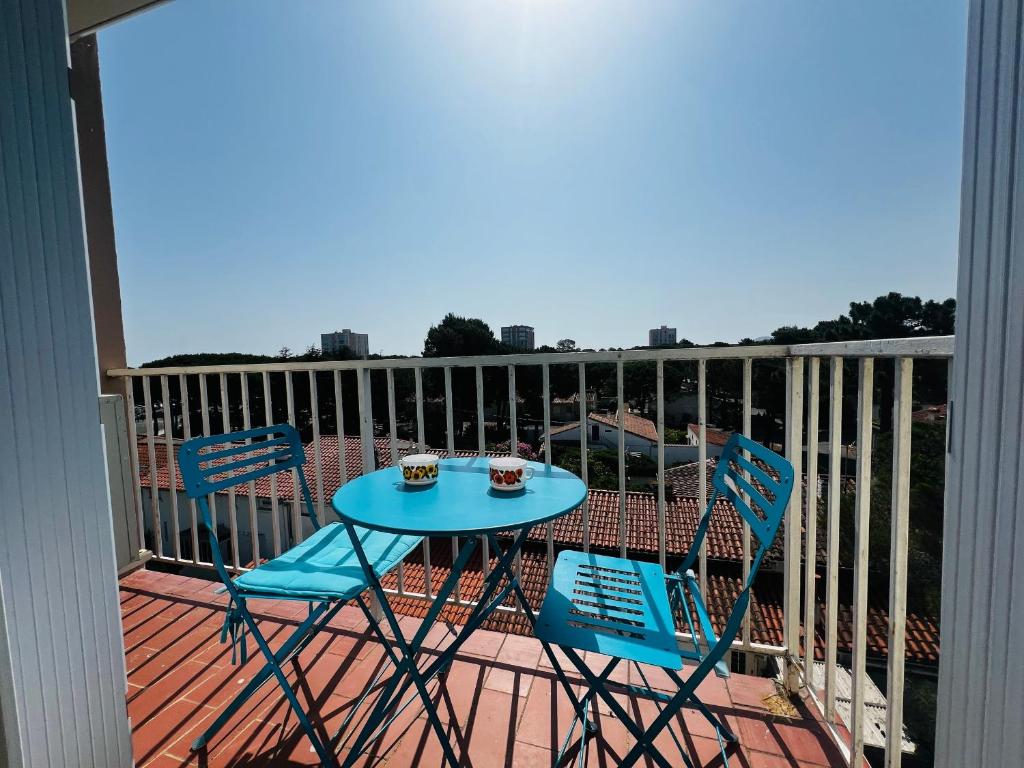 une table bleue et des chaises sur un balcon dans l'établissement Argelès: Appartement climatisé proche plage avec balcon, 4 couchages - FR-1-309-386, à Argelès-sur-Mer