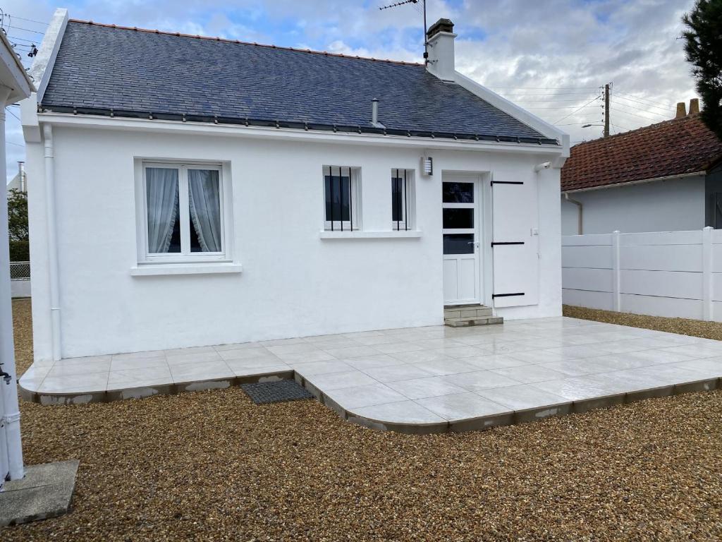 a white house with a patio in front of it at Maison rénovée proche plage Port Lin - 5 couchages - Jardin clos - FR-1-843-32 in Le Croisic