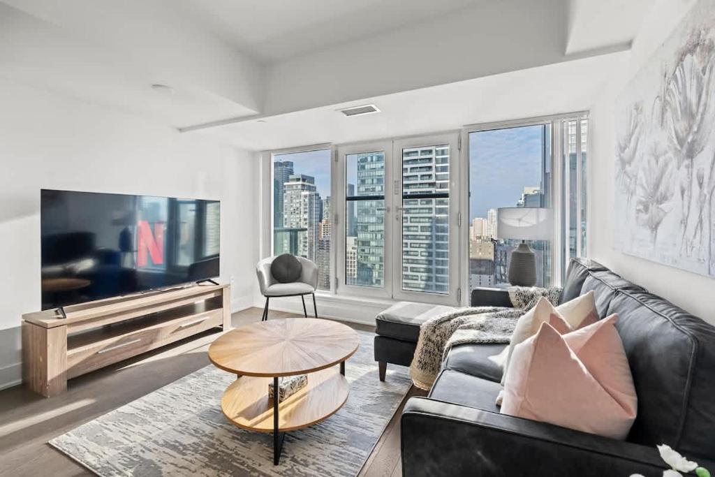 un salon avec un canapé et une table dans l'établissement Enjoy the City Skyline View with Pool & Gym, à Toronto