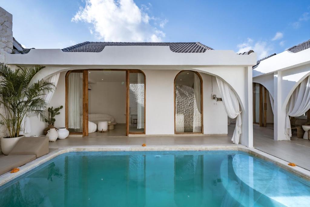 a villa with a swimming pool and a house at Villa Estrella Seseh in Cemagi