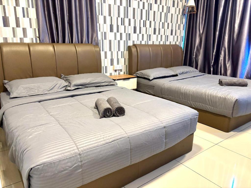 twee bedden naast elkaar in een slaapkamer bij Atlantis Residence Malacca by Mannisstay in Melaka