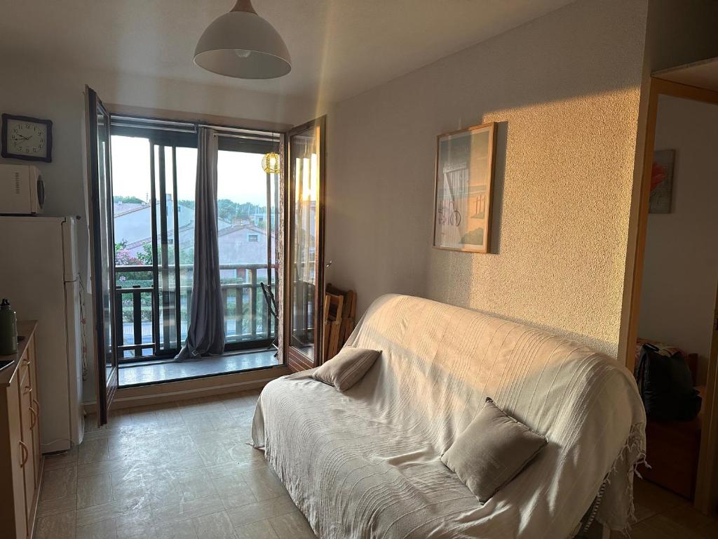 - une chambre avec un lit blanc et un balcon dans l'établissement Appartement T2 Saint Cyprien - 4 pers, parking - FR-1-793-35, à Saint-Cyprien
