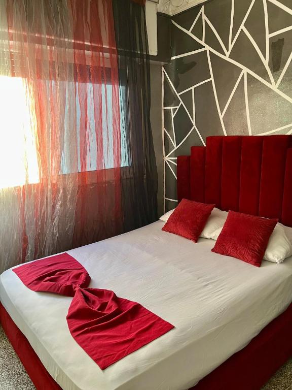 a bedroom with a bed with red pillows on it at Apparemment al baraka in Tangier