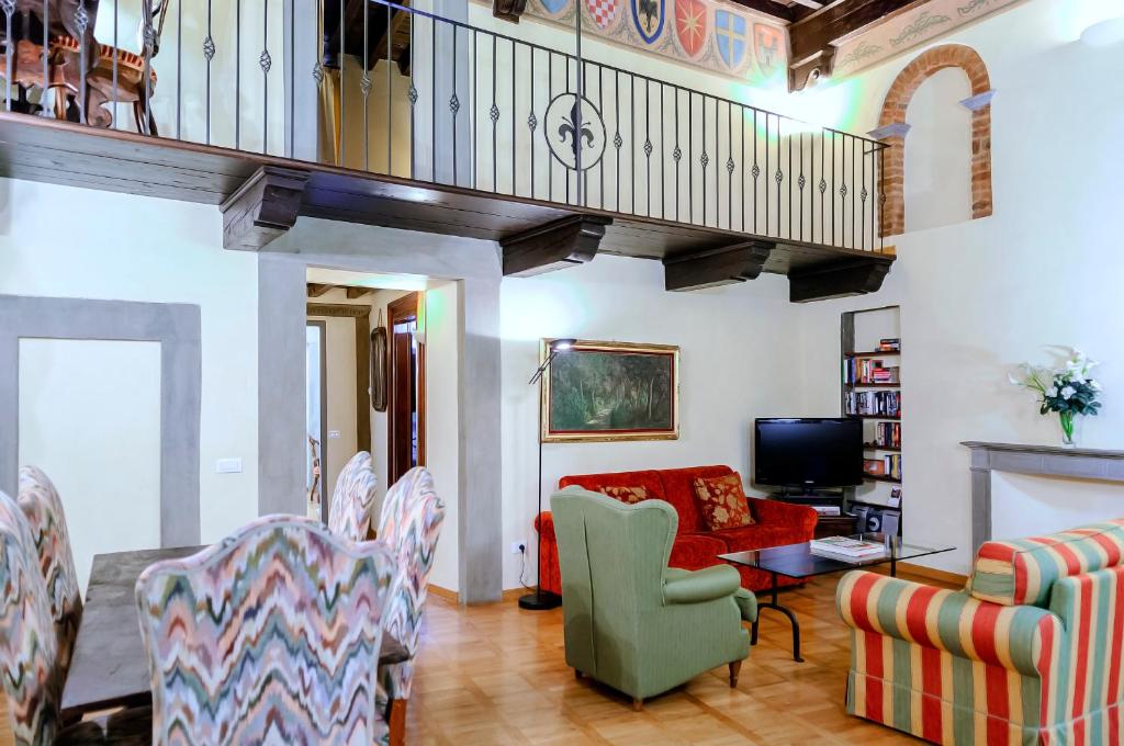 フィレンツェにあるCorno Florentine Apartment by 360Rentalsのリビングルーム(赤いソファ、椅子付)