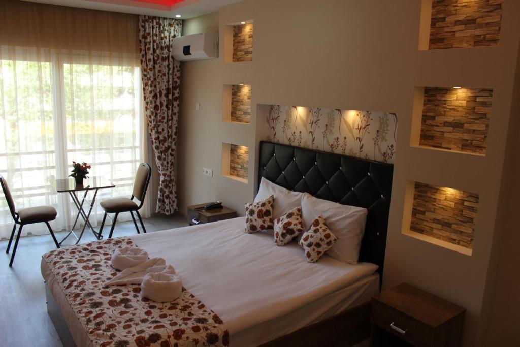 a bedroom with a large bed with two chairs at Efehan Hotel in İzmir