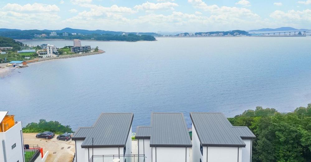 Blick auf einen großen Wasserkörper mit Häusern in der Unterkunft Ongjin Guardians Pool Villa in Sojang-gol