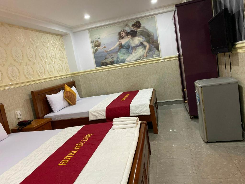 a hotel room with two beds and a painting on the wall at Duc Long Airport Hotel in Ho Chi Minh City