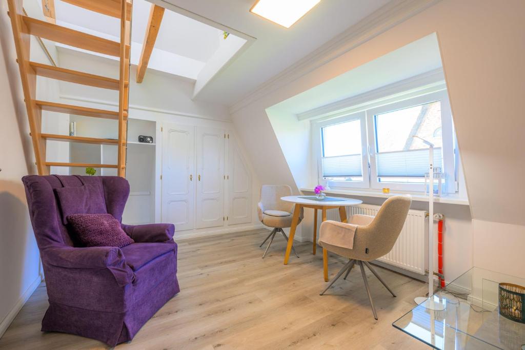 a living room with a purple chair and a table at Ferienwohnung-NEU-Weidenstieg-OG in Wenningstedt