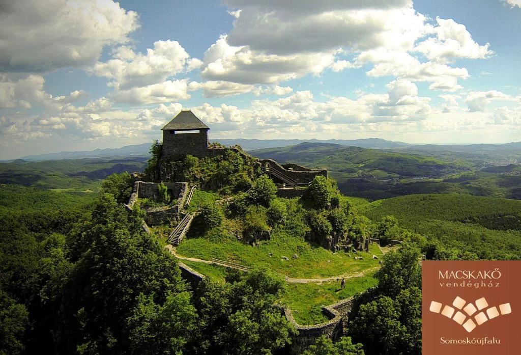 un edificio en la cima de una colina en las montañas en Macskakő Vendégház, en Somoskőújfalu