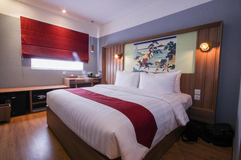 Postel nebo postele na pokoji v ubytování Kuretakeso Kemang Hotel