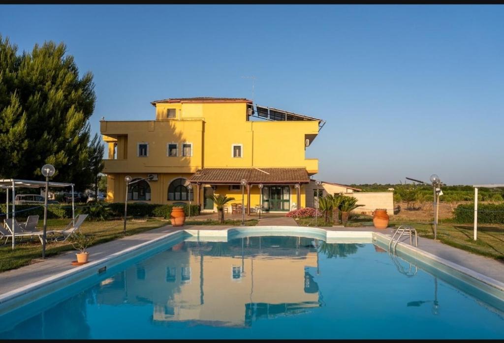 una casa con piscina di fronte a un edificio di Agriturismo l' Annunziata a Lizzano