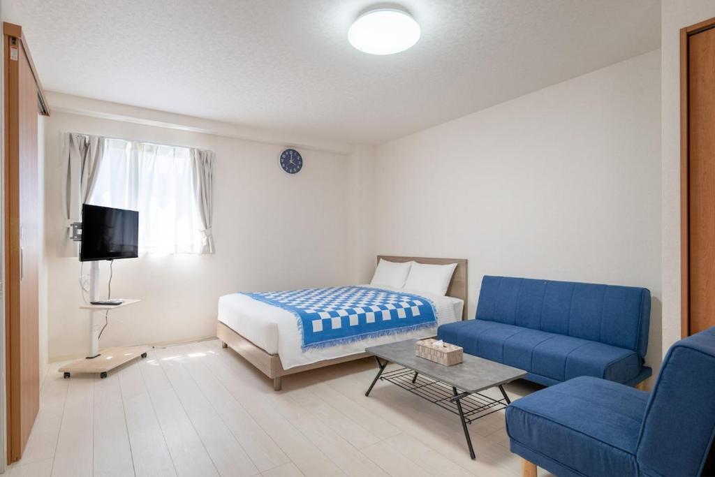 a bedroom with a bed and a blue couch at -Park Higashiueno301- 4-minute walk from Ueno Station in Tokyo