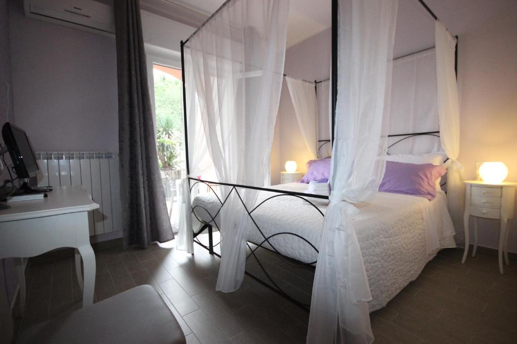 sypialnia z łóżkiem z baldachimem i oknem w obiekcie B&B Ai Tre Archi w mieście Spotorno