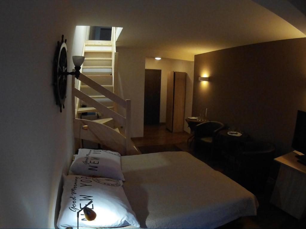 a hotel room with a bed and a staircase at Dolphin House in Łeba