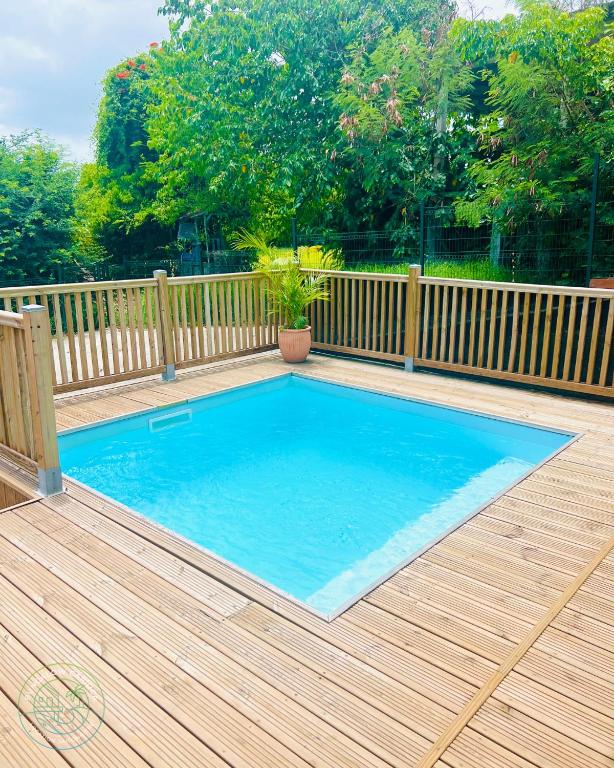 a swimming pool on a deck with a wooden fence at Bungalow Carioca Vue mer piscine privée au calme in Le Robert