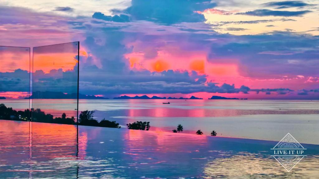 una piscina con vista sull'oceano al tramonto di Santi Vista Villas a Ko Samui