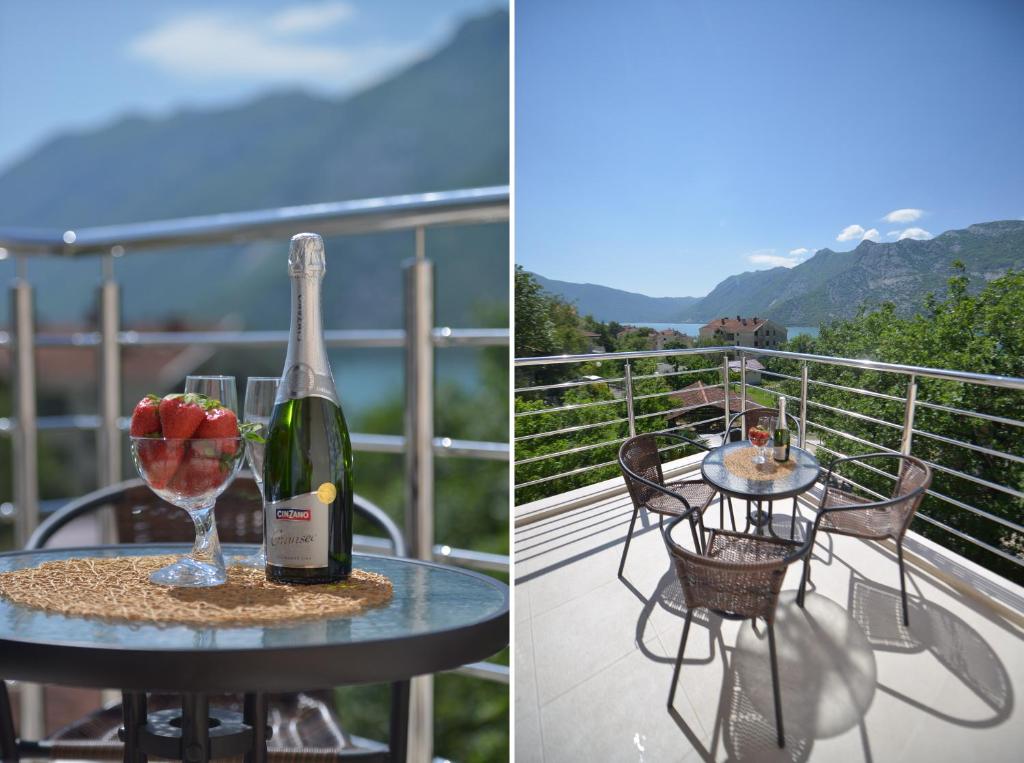butelkę wina i kieliszek na stole na balkonie w obiekcie Apartments Risan w mieście Risan