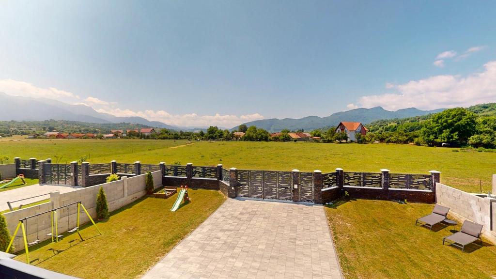 Una vista de un campo con una valla y bancos. en D&M Family Residence Bran 2, en Bran
