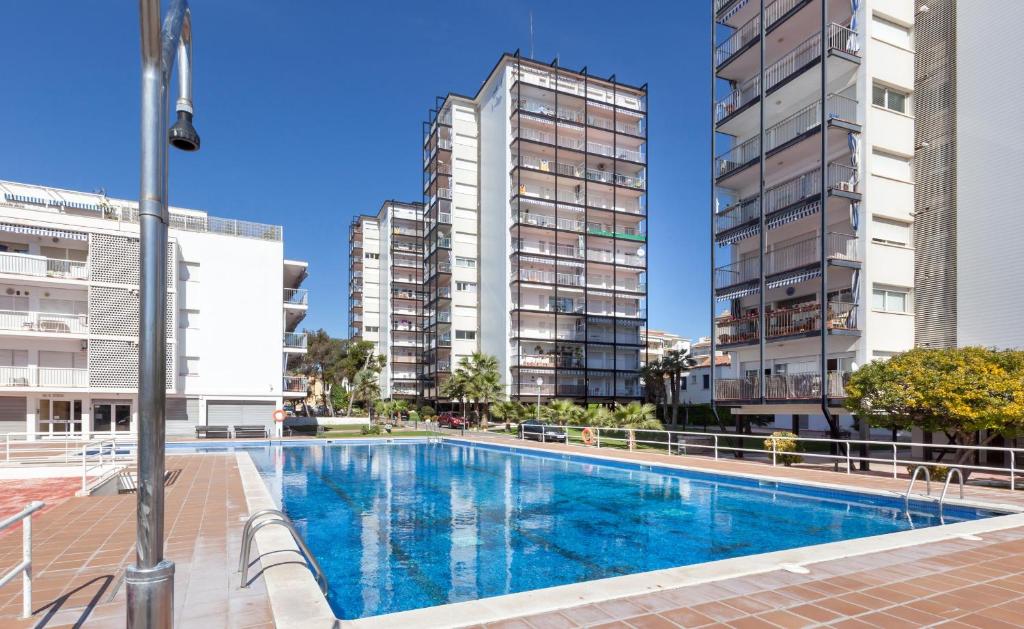 a swimming pool in the middle of two tall buildings at Hola! - El Cortijo in Sitges