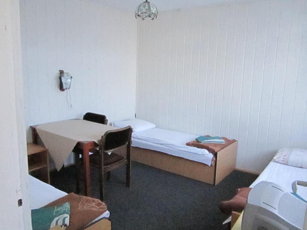 a small room with a small bed and a table at OW Gromada Pod Topolami in Międzyzdroje
