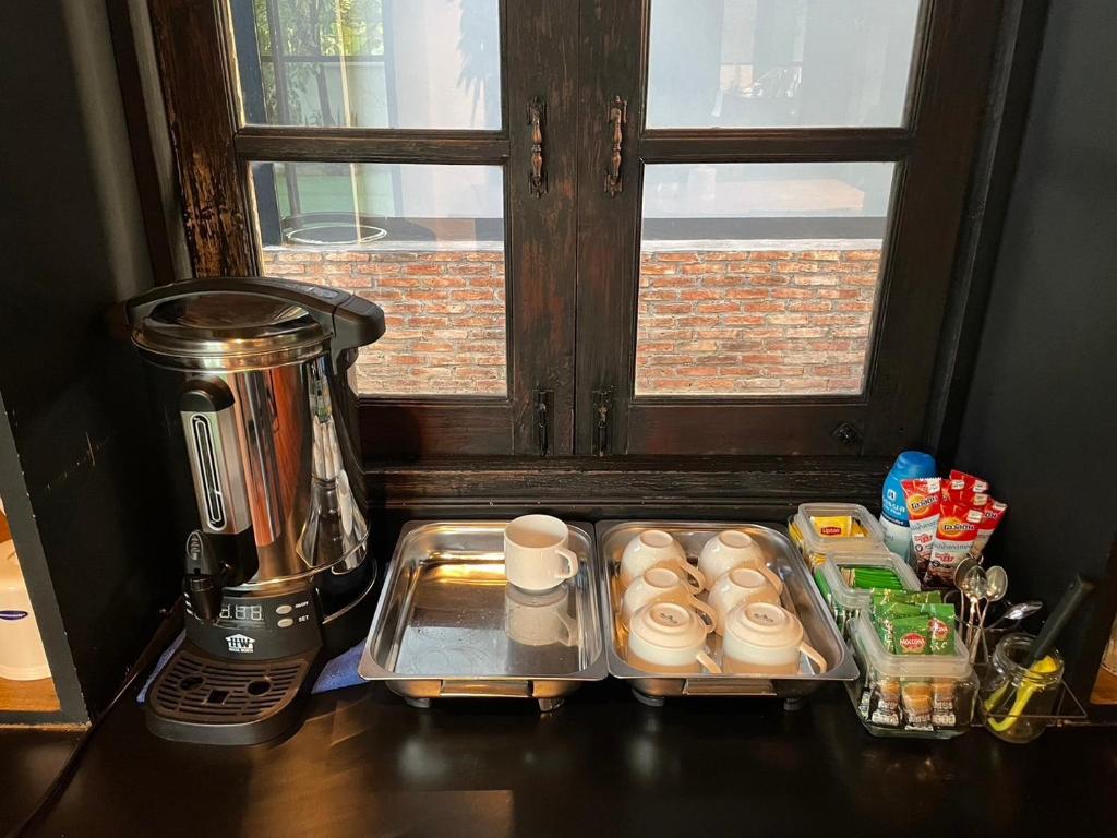 A compact self-service drinks and snack station beside a window.